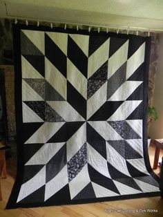 a black and white quilt hanging from the ceiling