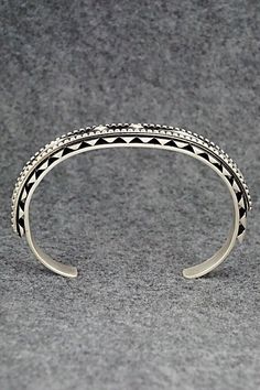 This sterling silver bracelet was made by Navajo silversmith Leander Tahe. The inside is signed L. Tahe and stamped sterling.Size: 5 3/4" (will fit up to a 7 1/8" wrist)Gap: 1 3/8"Width: 3/8"Free shipping on all orders! We ship with USPS and always include tracking. All orders ship within a day of payment.Returns are accepted up to 30 days after you receive your order. Just send us a message. Our shop offers cash back or store credit. The item must be returned in new condition. Silver Bohemian Cuff Bracelet With Inlay, Bohemian Silver Cuff Bracelet With Inlay, Silver Bohemian Bracelets With Inlay, Sterling Silver Inlay Bracelets In Silver Color, Silver Inlay Cuff Bracelet Bangle, Southwestern Silver Cuff Bracelet With Inlay, Adjustable Silver Bangle With Inlay, Silver Bohemian Hand Tooled Bracelets, Bohemian Silver Hand Tooled Bracelets