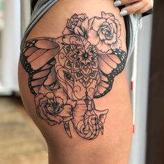 a woman's thigh with a butterfly and roses tattoo design on the side of her thighs