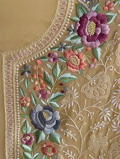 an embroidered dress with flowers and leaves on the front, along with pearls in the back