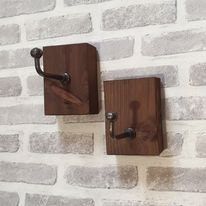 two wooden hooks on the side of a brick wall