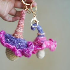 someone is holding two small knitted items in the shape of an elephant and a car