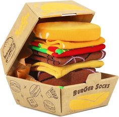 Features Unisex hamburger socks box set Presented in a realistic-looking burger box Breathable and sweat-absorbent 4 pairs of socks in each box Pattern may vary SOFT, COMFY, AND HEAVY ON THE BURGERS - These white athletic socks feature a healthy helping of loaded burgers from toe to cuff. BURGERS GO WITH EVERYTHING - Whether you're wearing yoga pants at the grocery store or a full tuxedo at your little sister's wedding, Burger Socks are totally appropriate. NO BURGERS WERE WASTED IN THE MAKING O Unique Packaging Ideas, Cheap Gifts For Men, Gifts For Teenage Guys, Sock Packaging, Funny Burger, Hamburger Box, Funny Socks For Men, Unique Packaging Design, Burger Box