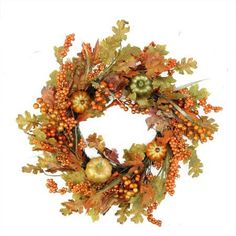 a wreath with oranges, berries and acorns hanging from it's sides