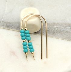 Blah, Blah.....Turn heads with these show-stopping Cheval Earrings! A beautiful blend of warm gold and cool teal turquoise will make your look irresistible. Slip the golden threaders through and amplify your allure with a little turquoise bling. 14k Gold Filled Measure approximately 1.25 Inches Quality Miyuki Seed Beads Sent in a Ribboned Gift Box Handmade in Montana Turquoise Earrings With Gold Beads, Gift Box Handmade, Open Hoop Earrings, Box Handmade, Teal Turquoise, Fall Earrings, Delicate Earrings, Stunning Earrings, Precious Jewelry