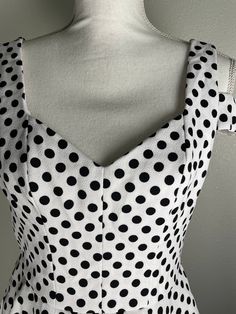 This Betsey Johnson polka dot dress is such a cutie!  It has a white background with is covered with snappy little black dots. It is a fit and flair frock with a sweet heart neckline, a back zipper and a very interesting shoulder strap design across the upper arm. To top it offit has pockets! It is in very good preowned condition. It is a size 6 but remember that Betsey's clothes tend to run small. Measurements are taken with garment laying flat.  17 1/2 underarm to underarm  15 inches across wa Polka Dot Square Neck Party Dress, Polka Dot Square Neck Dress For Parties, Summer Polka Dot Dress With Sweetheart Neckline, Chic A-line Mini Dress In Polka Dot, Chic A-line Mini Dress With Polka Dots, Fitted Polka Dot Dress With Sweetheart Neckline, Elegant Polka Dot Dress With Sweetheart Neckline, Fitted Polka Dot Dress With Square Neck, Elegant Polka Dot Dress With Square Neck