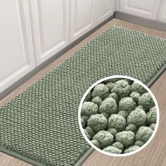 a kitchen mat with green balls on the floor next to white cabinets and cupboards