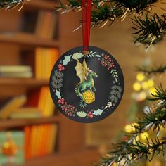 a christmas ornament hanging from a tree in front of a book shelf with books