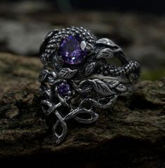 Handcrafted for enchanting souls, our ethereal fairy witchy wedding ring set embodies mystical allure and magical elegance. Crafted from sterling silver, it features intricate details inspired by celtic fantasy, including delicate branches and leaves, complemented by a striking dragon motif. The enchanting purple hue adds a touch of magic to this silver witches knot jewelry, making it a perfect choice for those seeking a unique and mystical accessory set for their special day. Characteristics: Metal - Recycled solid sterling silver  Stone - Cubic Zirconia Finish - Oxidized. View all silver dragon rings: https://www.etsy.com/shop/TinyShinyJewel?ref=seller-platform-mcnav&section_id=45210616 Care instructions: To care for the ring, avoid contact with water and chemicals such as perfumes and l Magical Silver Crystal Promise Ring, Silver Magical Crystal Promise Ring, Mystical Silver Jewelry With Intricate Design, Mystical Silver Crystal Ring For Anniversary, Silver Mystical Crystal Ring For Anniversary, Mystical Style Silver Promise Ring, Mystical Silver Promise Ring, Magical Silver Crystal Ring For Anniversary, Handmade Magical Silver Crystal Ring