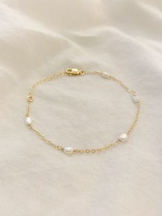 5-PEARL BRACELET This dainty bracelet has tiny natural shaped pearls on a string of 14K Gold Filled or Sterling Silver chain. Each Pearl is hand wrapped. This bracelet looks gorgeous layered with other gold bracelets, or looks beautiful and minimal worn alone. Gold Filled and Sterling Silver are hypoallergenic and tarnish resistant. △ 3-4mm freshwater Pearls △ Dainty 14K Gold Filled Chain or Sterling Silver with a quality 14K Gold Filled or Sterling Silver lobster clasp. △ Choose your length See Delicate Chain Bracelet With Extender, Delicate White Bracelets For Bridesmaids, Delicate White Bracelet For Bridesmaid, Adjustable Delicate Chain Gold Bracelet For Wedding, Dainty Gold Bracelet With Adjustable Chain For Wedding, 14k Gold Chain Bracelet For Wedding, Dainty Gold Bracelet With Delicate Chain For Wedding, Wedding Chain Bracelet With Extender, Delicate Hypoallergenic Chain Bracelet For Wedding