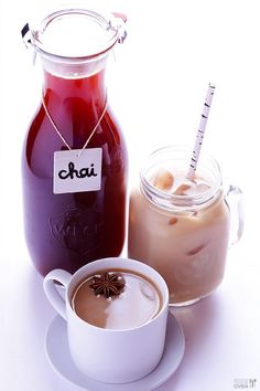 there is a cup of coffee next to a jug of liquid and a glass jar