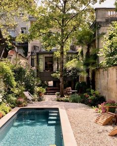 an outdoor swimming pool surrounded by trees and plants