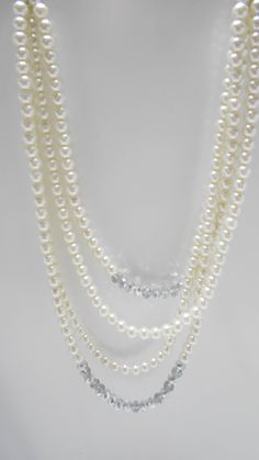 "Gorgeous vintage faux pearl necklace. Four strands of 8mm faux pearls & crystals. The end strands consist of two 6\" strands of rhinestone rondelles, silver tone bead spacers, various mm sizes of faux pearls and a crystal. The faux pearl graduating strands are 15\" - 21\" long. Lobster claw fastener. This is a very heavy necklace. Excellent condition. Unsigned." Classic Multi-strand Pearl Necklace For Wedding, Elegant Multi-strand Beaded Necklaces For Formal Occasions, Classic Beaded Pearl Necklace For Evening, Elegant Pearl And Beaded Rhinestone Necklace, Elegant Pearl And Rhinestone Beaded Necklace, Elegant Beaded Pearl Rhinestone Necklace, Vintage Pearl Necklaces With Rhinestones, Elegant Beaded Rhinestone Necklace With Round Beads, Formal Pearl Necklace With Rhinestones