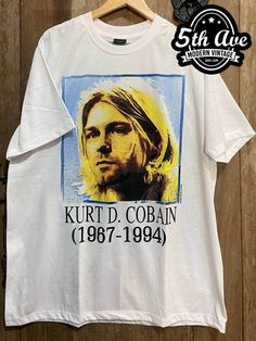 #kurtcobain #nirvana #smellsliketeenspirit #americanmusician #americanrockband #grunge #alternative #hardrock #rock #rockband #rockt #rocktee #band #bandt #bandtee #bandtshirt #rockbandtshirt #rockbandtee #tshirt #tee #streetwear #vintagereprint #y2k #shopvintage #thrift #thriftshop #90sstyle #vintageclothing #vintaget #bootleg White Grunge T-shirt For Music Festivals, Vintage Crew Neck T-shirt With Custom Artwork, Vintage Cotton T-shirt With Custom Artwork, Vintage Custom Print T-shirt For Fan Merchandise, White Custom Print Grunge T-shirt, Casual White T-shirt With Custom Artwork, Casual White T-shirt For Music Festivals, Retro Crew Neck T-shirt With Custom Artwork, White Band Merch Top With Custom Artwork