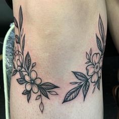 a close up of a person's leg with flowers and leaves on the side