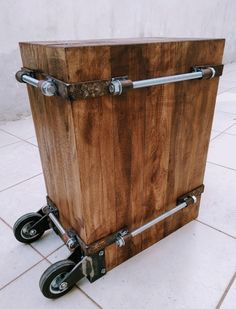 a large wooden box sitting on top of a tile floor next to a white wall