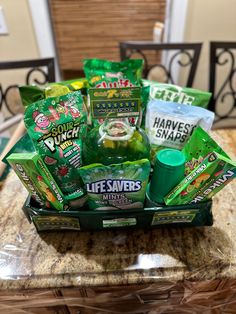 an assortment of snacks and drinks in a basket on top of a marble countertop