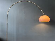 a lamp that is on the side of a wall next to a chair and table