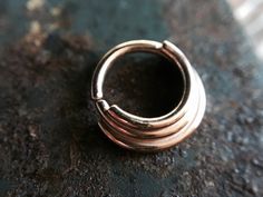 I made this lovely septum ring entirely from solid 14 karat rose gold. It is made to look layered. Twist open and closed to keep the circle shape, the ends are smooth for easy insertion. Can be worn in a variety of piercings. This nose ring is finished with a shiny high polish. Choose your gauge and inside diameter for a custom fit! Comes beautifully packaged and ready for gift giving! Check out my other nose rings here: https://www.etsy.com/shop/DinanRings?section_id=13671263&ref=shopsectio Septum Piercing, Nose Ring Stud, Nose Rings, Ear Piercing, Gold Dipped, Circle Shape, Tragus, Conch, Helix