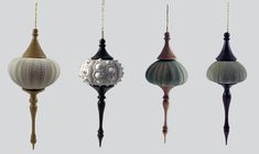 four different types of lights hanging from strings on a gray background, each with an ornament in the shape of a ball