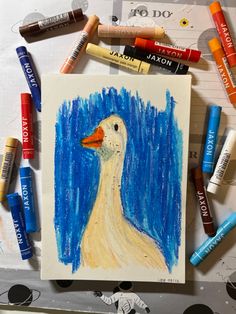 some crayons and markers are surrounding a drawing of a white duck with orange beak