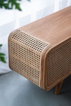 a close up of a wooden table with a plant in the background