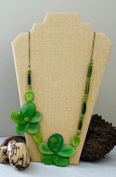 Handmade in Ecuador Necklace Length: 28 Inches Material: Tagua Nut Gold Handmade Clasp Due to this item being handmade and the nature of the Tagua Nut the size and the color may vary from piece to piece Artisan Green Jewelry With Wooden Beads, Artisan Green Jewelry For Beach, Green Long Necklace For Beach, Long Green Necklaces For The Beach, Green Wooden Beads Jewelry For Beach, Handmade Green Flower Beaded Necklaces, Adjustable Green Beaded Necklace In Nature-inspired Style, Adjustable Green Beaded Necklace With Nature-inspired Style, Beach Jewelry With Green Wooden Beads