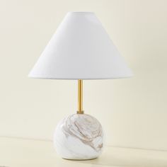 a marble lamp with a white shade on it