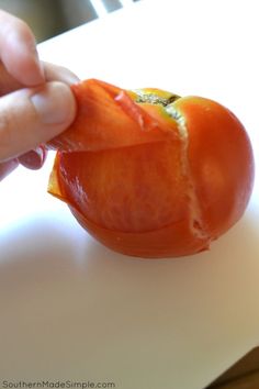 a person is peeling an orange on a cutting board