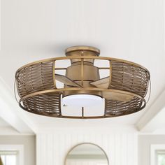 a ceiling fan in the middle of a living room with white walls and wood floors