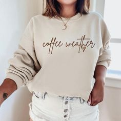 The "Coffee Weather Sweatshirt" is a sturdy and warm sweatshirt bound to keep you warm in the colder months. A pre-shrunk, classic fit sweater made with love for you & your loved ones! Sweatshirt Details: * Gildan sweatshirt - unisex fit * 50% cotton, 50% polyester * Pre-shrunk * Classic fit with no center crease * 1x1 athletic rib knit collar with spandex * Air-jet spun yarn with a soft feel and reduced pilling * Double-needle stitched collar, shoulders, armholes, cuffs, and hem * Model is wear Cozy Gifts, Sweatshirt Details, Custom Sweaters, Gildan Sweatshirt, Cozy Gift, Fall Gifts, Gildan Sweatshirts, Fall Sweatshirt, Cozy Sweatshirts