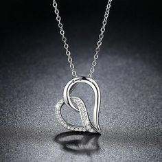 An exaggerated heart is a sure sign of love. Graceful shiny lines meet sparkling Cubic Zirconias. Includes an 18-inch twisted Singapore style chain. A truly unique design. The perfect gift for someone you love. Materials: White or Rose Gold plating over copper Stones: AAA Cubic Zirconia Size: 2.3cm (approximately 1 inch x .75 inch overall) Chain: 18 inch with 2 inch extension Comes gift boxed(Reg $59.95) Singapore Style, Sign Of Love, Twisted Heart, Heart Pendant Diamond, Cz Pendant, Diamond Charm, Diamond Heart, Necklace For Women, Heart Necklace