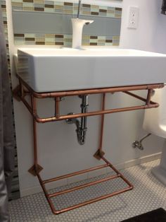 a white sink sitting next to a toilet in a bathroom under a faucet