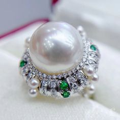 Highlight: Luxury South Sea Pearl Ring OriginSouth Sea Pearl Jewelry Processed in Japan MaterialSouth Sea Pearl, 18k Gold, Natural Diamond, and Emerald DimensionsRing Diameter Approx. 2.2 cm  Pearl Shaped: Round Size: 15-16 mm Quality: AAAA Nacre: Very Thick Color: White Luster: Aurora  Accessories Metal: 7.8 g of 18k White Gold Other: 1.25 ct of SI Quality Natural Diamond, and 0.38 ct of Emerald Exquisite White Gold Emerald Ring, Elegant White Metal Emerald Ring With Round Cut, Elegant White Emerald Ring With Round Cut, Elegant Diamond White Emerald Ring, White Emerald Ring With Diamond Accents For Gift, Gia Certified Luxury White Ring, White Emerald Ring With Diamond Accents As A Gift, Elegant White Emerald Ring For Formal Occasions, Aaa Quality Round Diamond Ring