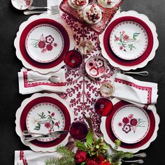 the table is set with red and white dishes