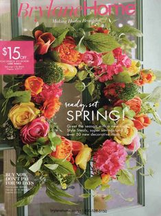 a magazine cover with a wreath on the front door and flowers in it's center