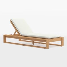 an outdoor chaise lounge chair made out of teak and white canvas, with the seat folded back