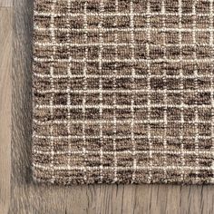 a brown and white rug on top of a wooden floor