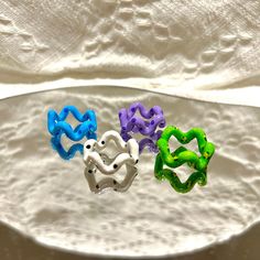 three different colored rings sitting on top of a white plate