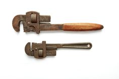 an old pair of scissors with wooden handles on each side, and two other tools attached to the blades