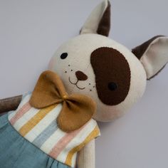 a stuffed animal with a brown bow on it's neck and striped shirt underneath