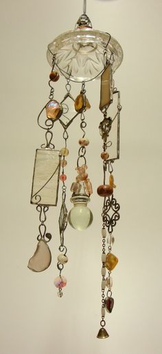 a chandelier hanging from the ceiling with glass beads and other items attached to it