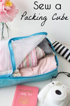 an open blue suitcase sitting on top of a white table next to a pink flower