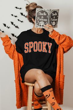 Spooky T-Shirt, Halloween T-Shirt, Cute Ghost Shirt, Cute Fall Shirts, Spooky Season Shirt, Orange Spooky Shirts, Retro Spooky Shirts Gildan 5000 - Heavyweight Cotton T-Shirt Features (G500): Made from 100% preshrunk cotton, the fabric of this t-shirt is highly breathable, is friendly to skin and doesn't shrink after washing. It has a seamless ribbed round neck collar with shoulder to shoulder taping on the inside to give a well-structured look to your shoulders. There is double stitching on the Spooky Short Sleeve Shirt With Letter Print, Spooky Crew Neck Shirt With Letter Print, Spooky Halloween Shirt With Letter Print, Spooky Orange Crew Neck T-shirt, Spooky Shirts, Cute Fall Shirts, Ghost Shirt, Halloween T Shirt, Cute Ghost