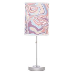 a lamp with a pink, blue and white marble pattern on the shade is shown