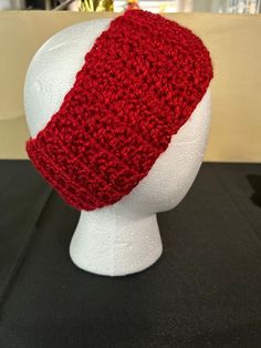 a red knitted hat on top of a white mannequin head