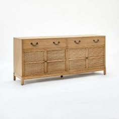 a wooden dresser with wicker drawers and handles