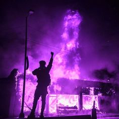 a man standing in front of a purple fire