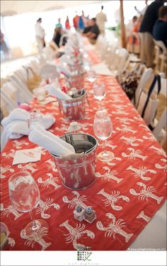 the table is set up with red cloths and place settings for people to sit at