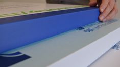 a person is cutting out some blue paper